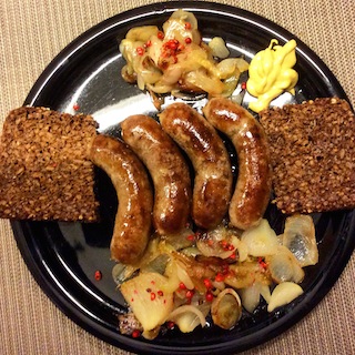 Schweinsbratwürstchen mit Zwiebelgemüse, scharfer Senf, Vollkornbrot